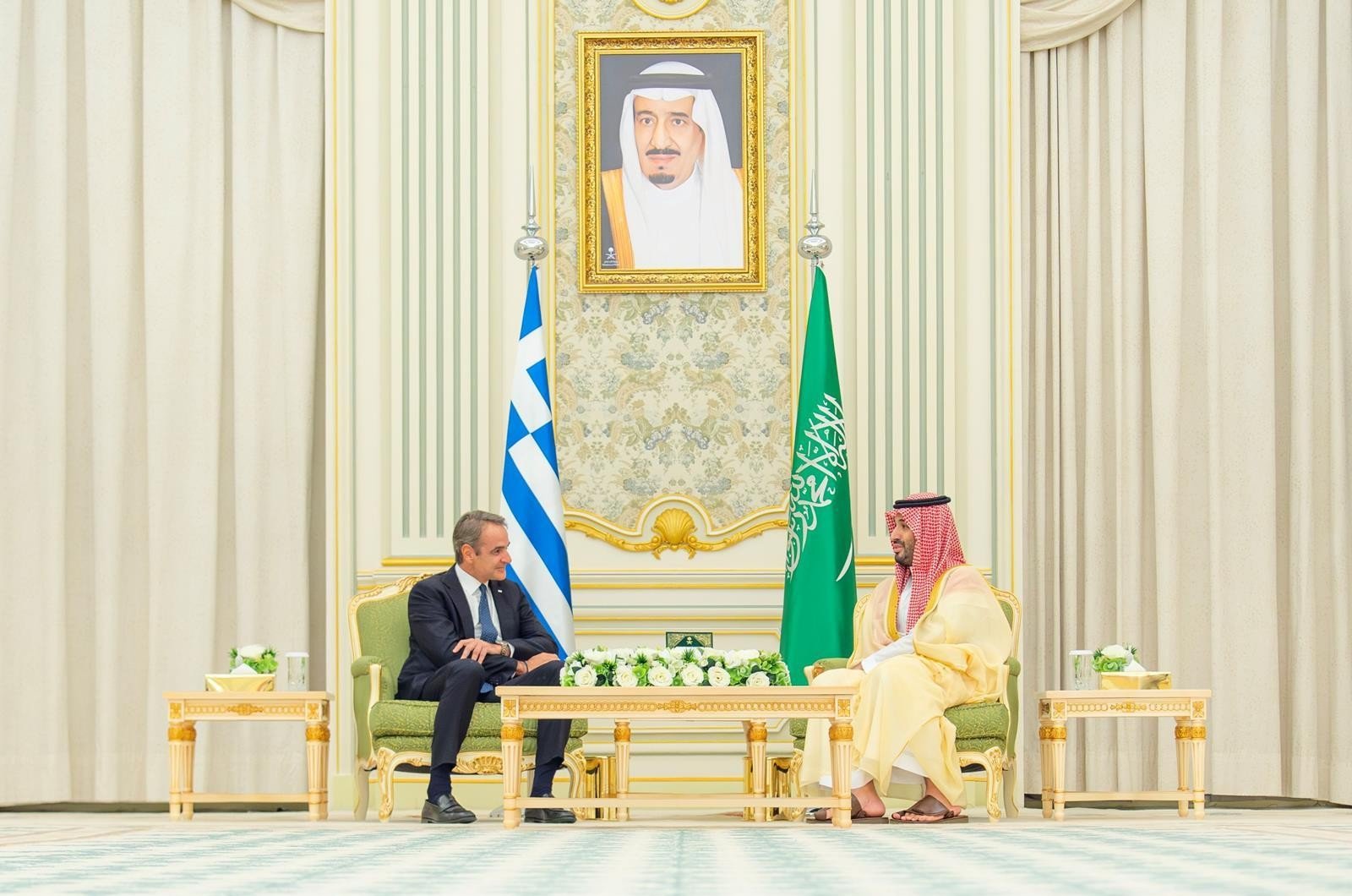 Saudi Crown Prince Mohammed bin Salman and Greek Prime Minister Kyriakos Mitsotakis seated in talks in Riyadh with Saudi and Greek flags