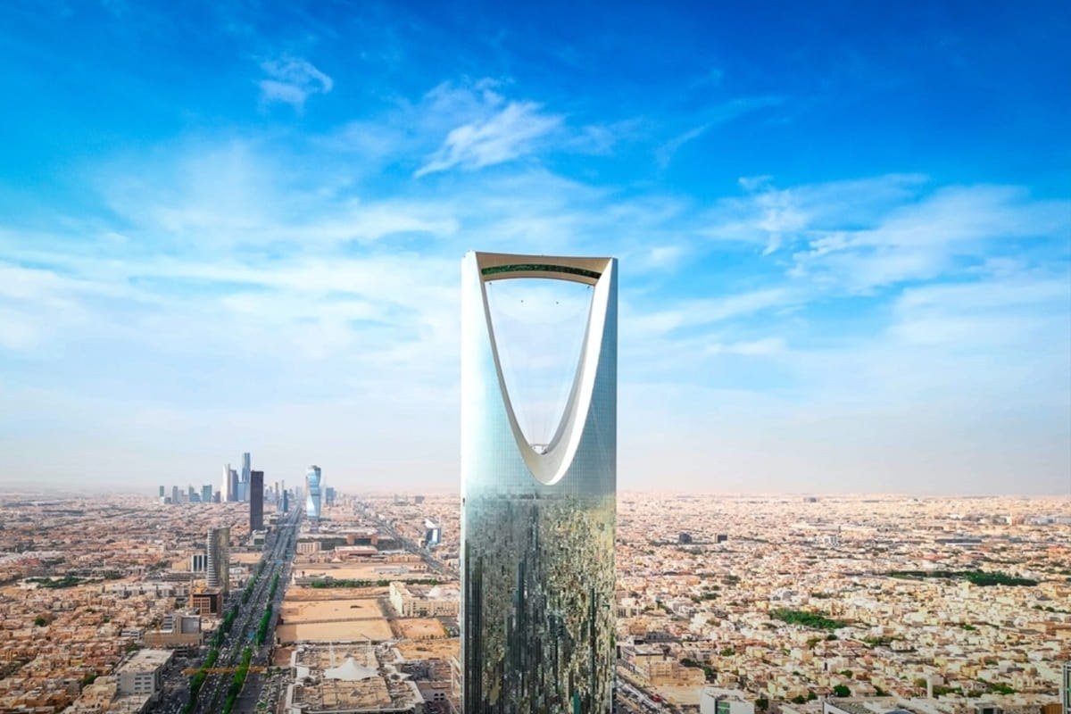 Aerial view of the Kingdom Centre tower and central Riyadh under a blue sky