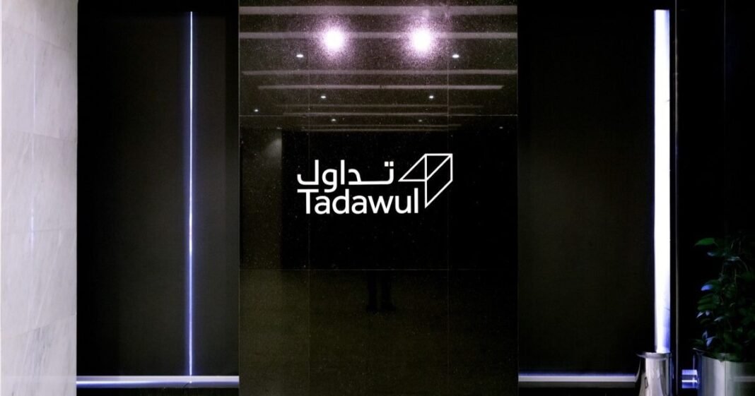 Tadawul signage in Arabic and English on a dark marble wall at the Saudi exchange operator's offices