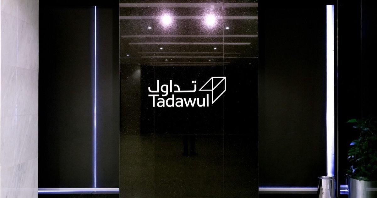 Tadawul signage in Arabic and English on a dark marble wall at the Saudi exchange operator's offices