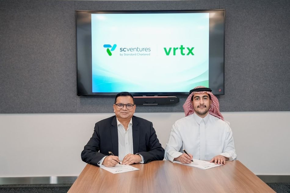 Gabriel Heredia of SC Ventures and Vrtx founder Mishal Bin Slimah signing documents at a table beneath a screen showing both company names