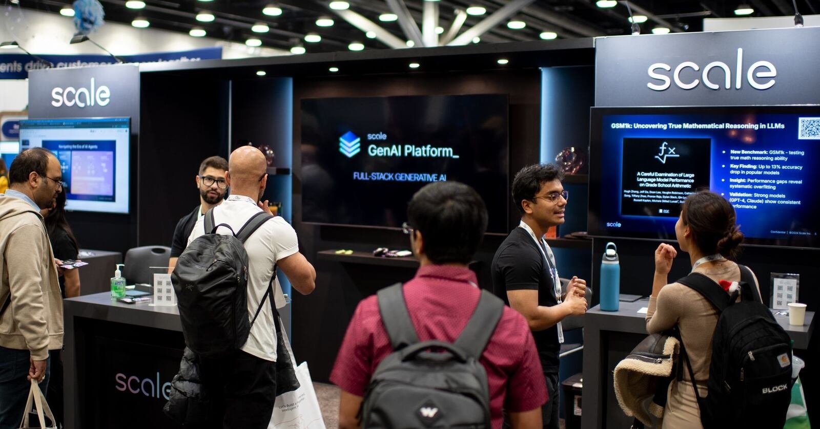 Visitors talk with staff at a Scale AI exhibition stand showing its GenAI Platform on screens
