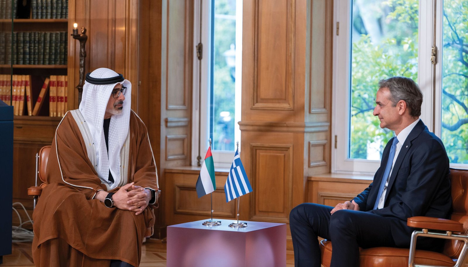 Abu Dhabi Crown Prince Sheikh Khaled bin Mohamed and Greek Prime Minister Kyriakos Mitsotakis seated facing each other with UAE and Greek flags between them