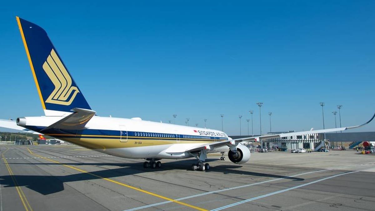 A Singapore Airlines Airbus A350 parked on an airport apron under a clear sky