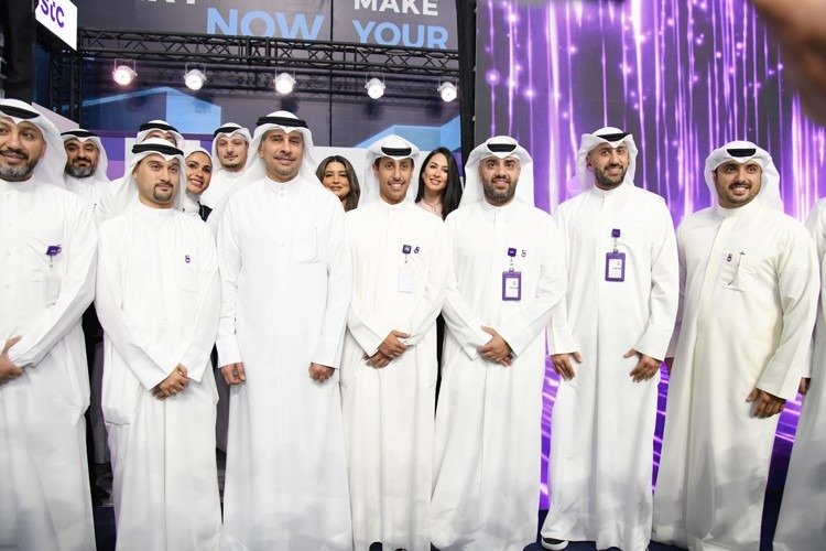 Kuwait Telecommunications Company stc staff in traditional dress pose together at the company's stand at the Wazifati careers fair in Kuwait