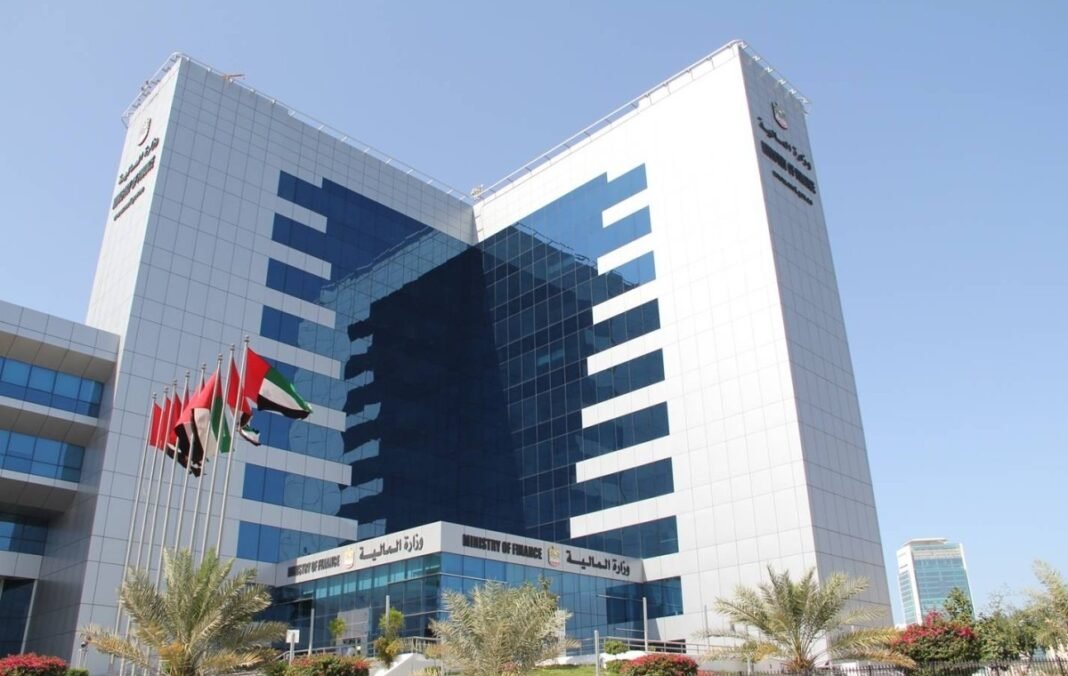 The UAE Ministry of Finance headquarters building with flags and palm trees in front