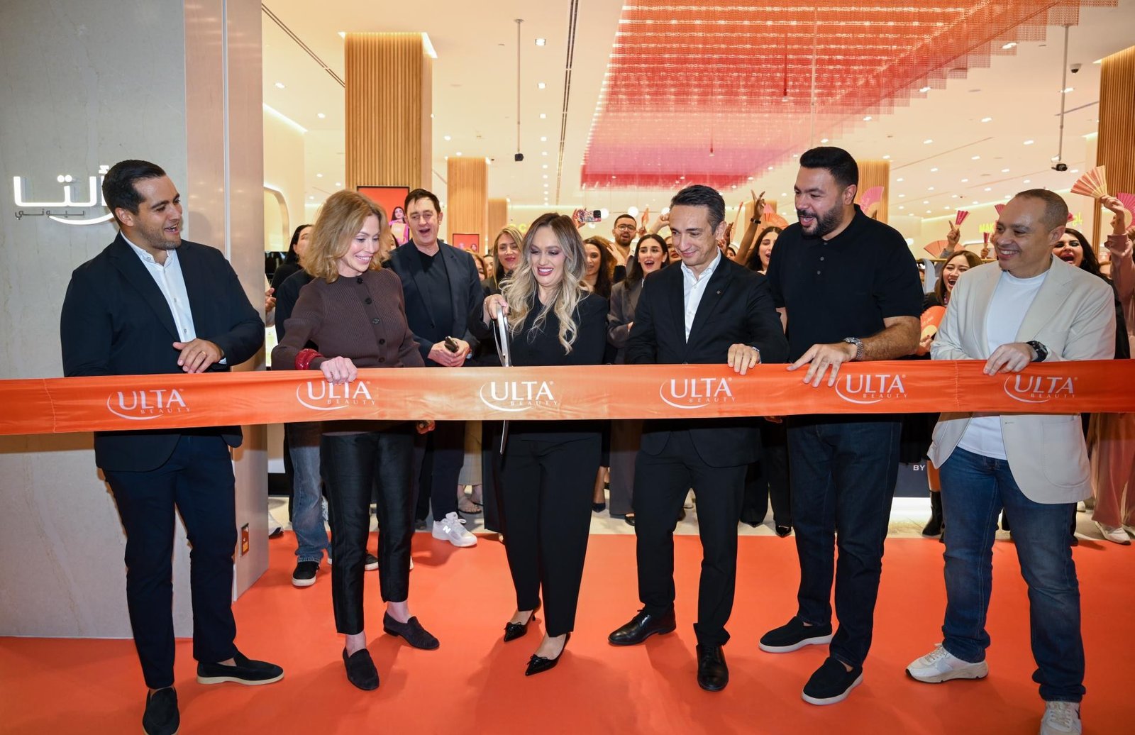 Executives cut an orange Ulta Beauty ribbon at the opening of the store at Doha Festival City