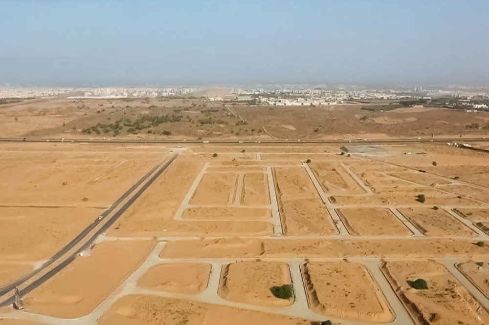 Aerial view of undeveloped desert land divided into plots by new roads on the edge of a Saudi city