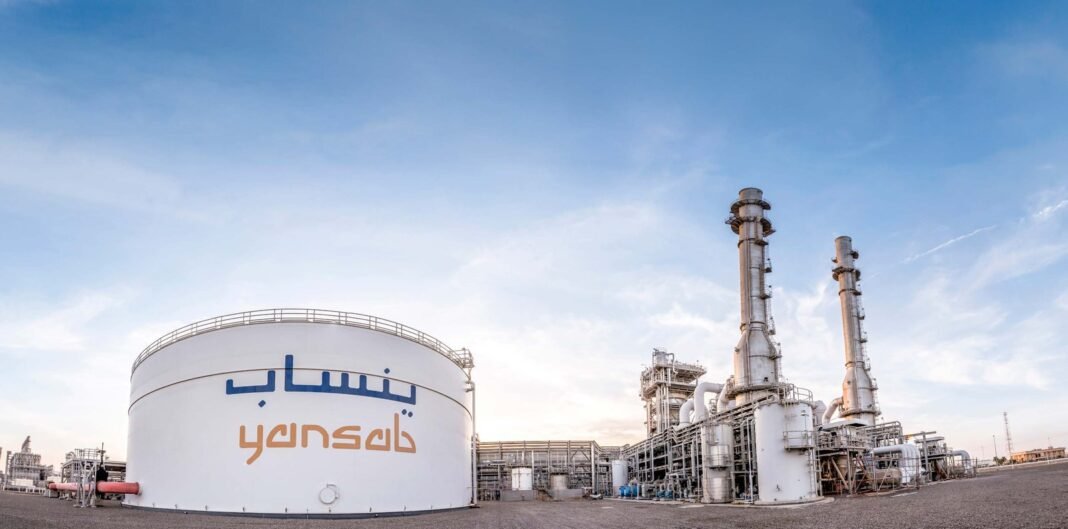 White Yansab storage tank with the company's Arabic and English name beside process units and stacks at its Yanbu petrochemical complex