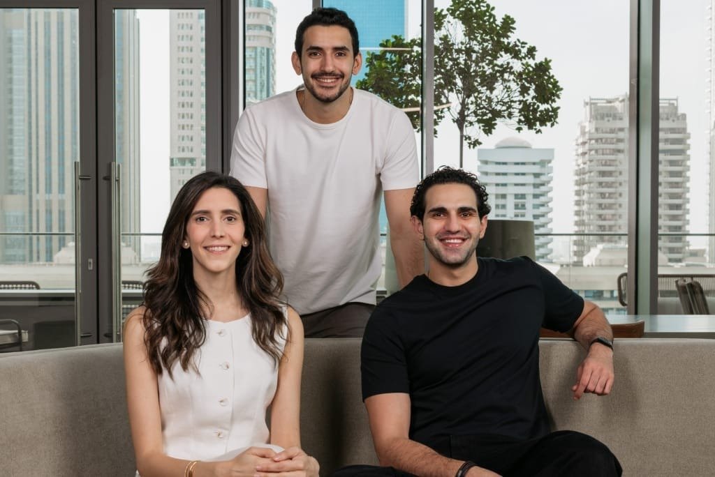 Ziina co-founders Sarah Toukan, Faisal Toukan and Talal Toukan in an office with Dubai towers visible through the windows